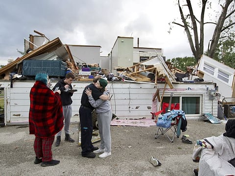 A family outside their damaged home in Woodridge, on June 21, 2021.