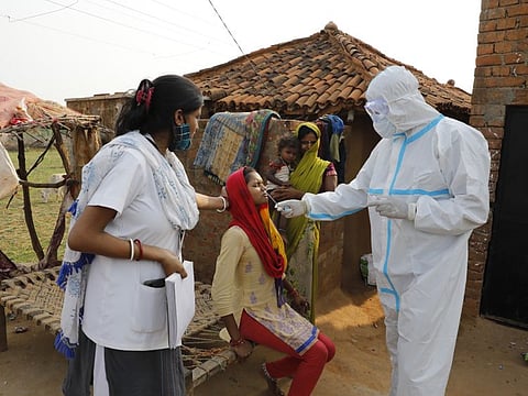 Health workers take nasal swab of a woman to test for COVID-19 in Jamsoti village in Uttar Pradesh. 