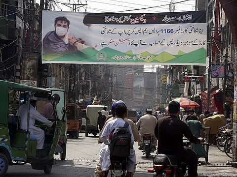 A banner explaining the COVID-19 vaccination process displayed to encourage people to get the jab in Peshawar.
