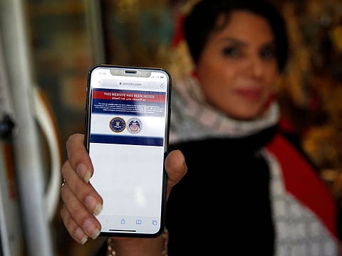 An Iranian woman shows on her mobile phone a statement declaring the website of Iran's English-language television station Press TV "has been seized by the United Government", in the capital Tehran on  June 23, 2021. 