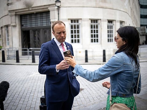 Britain's Health Secretary Matt Hancock, looks at the phone of his aide Gina Coladangelo as they leave the BBC in central London on June 6, 2021, after appearing on the BBC political programme The Andrew Marr Show. A British newspaper reported on June 25, 2021, that Britain's Health Secretary Matt Hancock has been having an affair with a close aide Gina Coladangelo, whom he appointed to his team in secret last year.