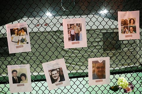 Pictures of missing people and flowers hang on a fence at the memorial for victims of a partially collapsed residential building as the emergency crews continue search and rescue operations for survivors, in Surfside, near Miami Beach, Florida, US June 25, 2021. 