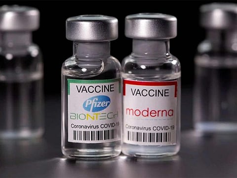 Vials with Pfizer-BioNTech and Moderna COVID-19 vaccine labels are seen in this illustration. 