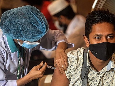  A health worker inoculates a man with a dose of the Oxford-AstraZeneca Covid-19 vaccine at the Bangabandhu Sheikh Mujib Medical University Hospital (BSMMU), in Dhaka on June 22, 2021. 