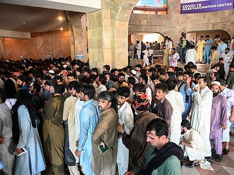 People, including overseas Pakistani workers, who want to fly to the Middle East stand in a queue to register before receiving a dose of the Pfizer Covid-19 vaccine at a vaccination centre in Islamabad on June 28, 2021.