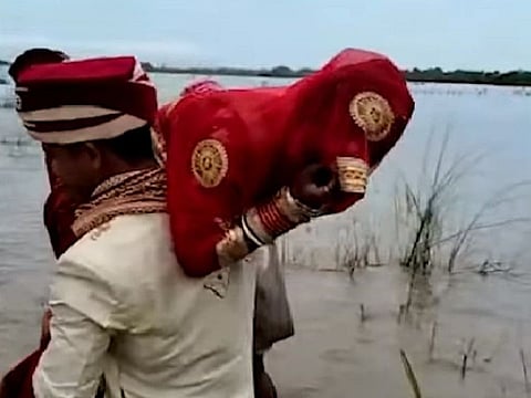 Shiv Kumar Singh carrying the bride across the river.