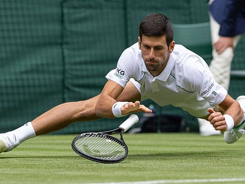 World No.1 Novak Djokovic of Serbia falls en route to his second round win over South Africa's Kevin Anderson at Wimbledon on Wednesday.