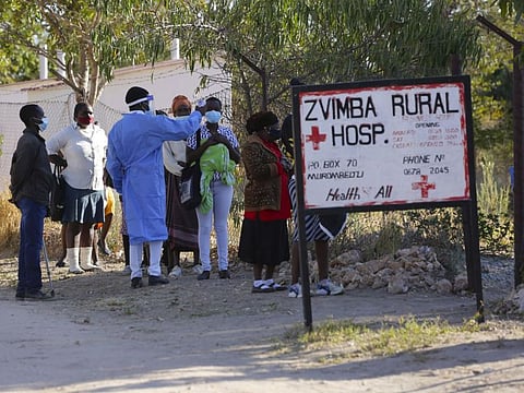 Residents of Zvimba in rural Zimbabwe have their temperatures taken before seeking treatment at the local hospital Friday, June, 25, 2021 photo.  A new surge of the coronavirus is finally penetrating Africa’s rural areas, where most people on the continent live, spreading to areas that once had been seen as safe havens from infections that hit cities particularly hard. 