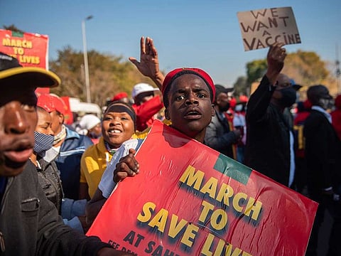In this Friday, June 25, 2021 file photo members of the Economic Freedom Fighters stage a protest march in Pretoria, South Africa, demanding that vaccines from China and Russia be included in the country's vaccine rollout program. The African Union special envoy tasked with leading efforts to procure COVID-19 vaccines for the continent is blasting Europe as Africa struggles amid a crushing third wave of infections. 