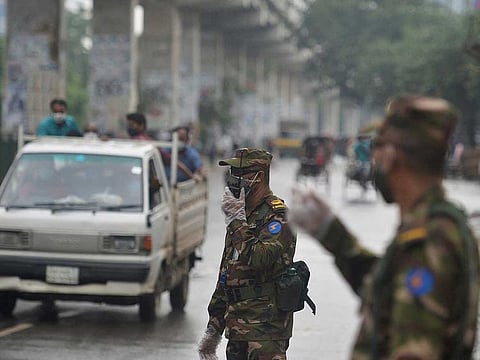 Bangladesh army personnel man a checkpoint along a road in Dhaka on July 1, 2021, during a strict COVID-19 lockdown, with the army and police ordered to stop people leaving their homes except for emergencies or to buy essentials. 
