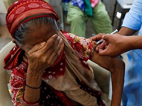 Basanti, 71, reacts as she receives a dose of the coronavirus disease (COVID-19) vaccine at a vaccination centre in Karachi, Pakistan June 9, 2021.