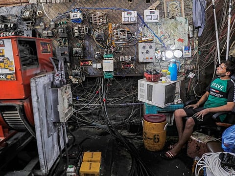 A technician keeps watch on an electric switch board connecting homes to privately-owned electricity generators in a suburb of Iraq’s capital Baghdad on June 30, 2021 as the national electric grid is experiencing outages amidst a severe heat wave. 