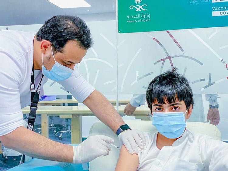 A schoolboy gets the shot against COVID-19 at a Saudi inoculation centre. 