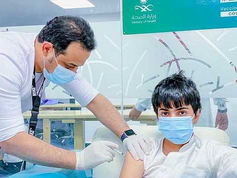  A schoolboy gets the shot against COVID-19 at a Saudi inoculation centre. 