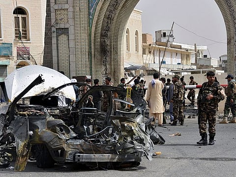  Afghan forces inspect the remains of a vehicle at the site of a bomb blast in Kandahar on July 4, 2021. 