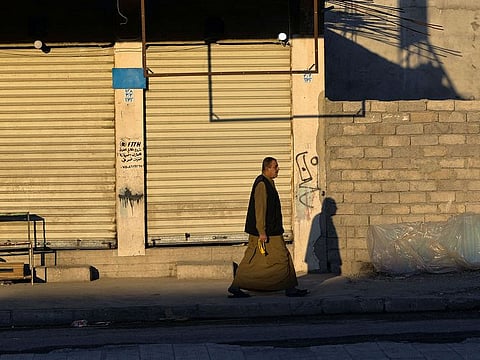 A man walks past shuttered shops in the Zanjili neighbourhood of Iraq's northern city of Mosul on March 19, 2021.