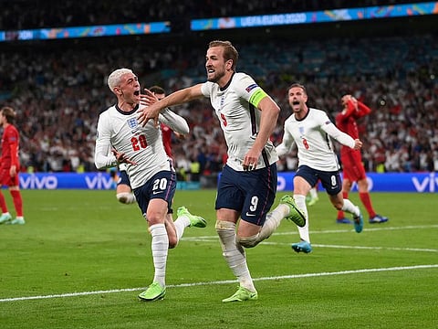 England's Harry Kane celebrates scoring against Denmark with Phil Foden.