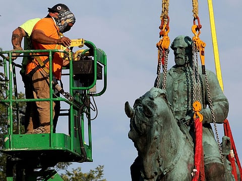 Workers remove a statue of Confederate General Robert E. Lee from Market Street Park on July 10, 2021 in Charlottesville, Virginia.  