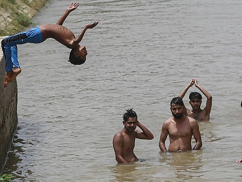Boys cool off with a swim in a canal on a hot summer day in Sri Ganganagar in the northern Indian state of Rajasthan.  