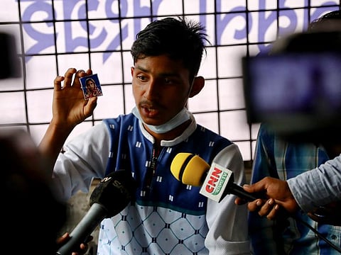 A man shows a picture of his mother who is missing after a fire broke out at a Hashem Foods Ltd factory in Rupganj, Narayanganj district, on the outskirts of Dhaka, Bangladesh, July 10, 2021. 