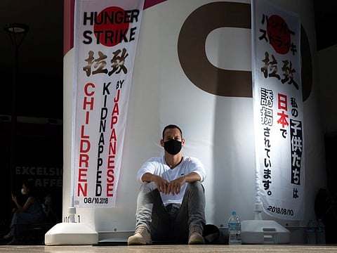 French resident Vincent Fichot, whose two children have been abducted by their Japanese mother,  outside a train station in Tokyo.