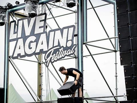 Members of staff dismantle the scenes built for the Live Again festival on July 10, 2021, in Erp, after its cancellation due to the growing number of people infected in The Netherlands. 