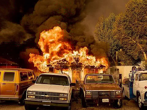 Flames consume a home as the Sugar Fire, part of the Beckwourth Complex Fire, tears through Doyle, Calif., on Saturday, July 10, 2021. Pushed by heavy winds amid a heat wave, the fire came out of the hills and destroyed multiple residences in central Doyle. 