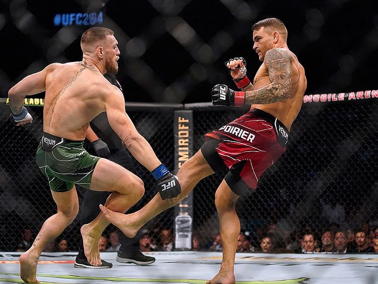 Dustin Poirier, right, kicks Conor McGregor during UFC 264 