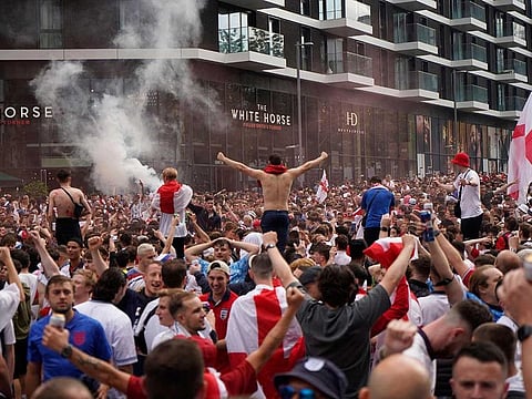 England fans cheer on their team outside Wembley Stadium ahead of the UEFA EURO 2020 final football match between England and Italy in northwest London on July 11, 2021. 