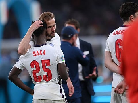England's Harry Kane consoles Bukayo Saka after the penalty shootout against Italy in the Euro 2020 final.