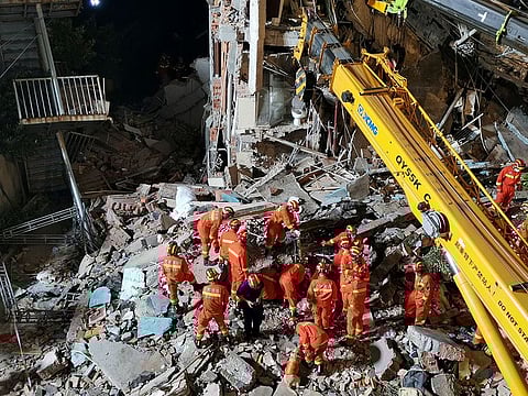 Rescue workers work next to a crane at the site where a hotel building collapsed in Suzhou, Jiangsu province, China July 12, 2021. 