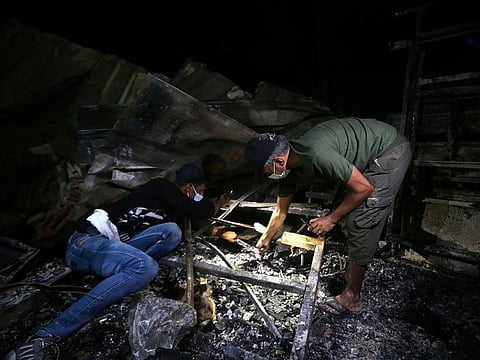 People inspect the damage at the site where a fire broke out at Al Hussain coronavirus hospital, in Nassiriya, Iraq, July 13, 2021