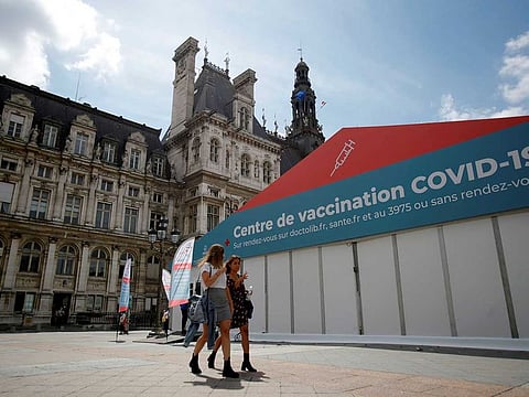 Women walk past a coronavirus disease (COVID-19) vaccination centre installated in front of Paris town hall, France, July 7, 2021. 
