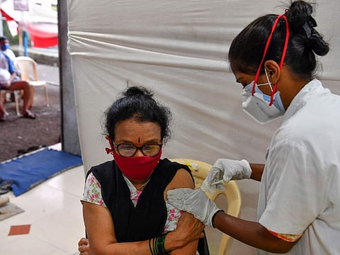 A resident is being inoculated with a dose of AstraZeneca-Oxford's COVID-19 vaccine, during a vaccination drive in Mumbai July 12, 2021.  