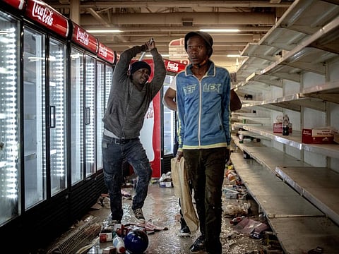 The owner of a shop beats a suspected looter in a shop in Bara Mall, Soweto on July 13, 2021. 
