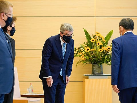 Thomas Bach, International Olympic Committee President (centre), bows to Japanese Prime Minister Yoshihide Suga during his courtesy call at the Prime Minister's official residence in Tokyo on Wednesday. 