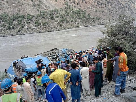 Local residents and rescue workers gather at the site of bus accident, in Kohistan Kohistan district of Pakistan's Khyber Pakhtunkhwa province, on July 14, 2021.
