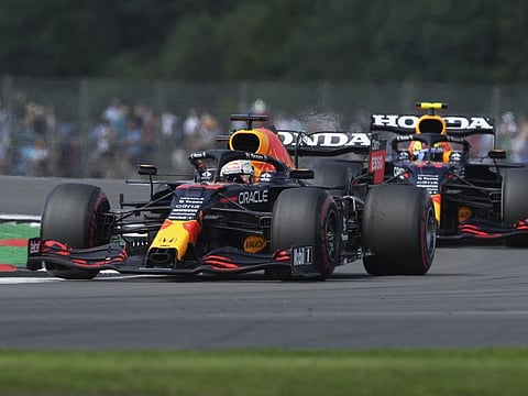 Red Bull driver Max Verstappen of the Netherlands leads teammate Sergio Perez of Mexico, right, into a curve during the first free practice session ahead of Sunday's British Formula One Grand Prix, at the Silverstone circuit, in Silverstone, England, Friday.