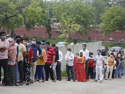 People stand in a queue to get vaccinated in Ahmedabad, India, on July 16, 2021. 