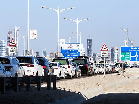 Kuwaitis queue in their cars to receive a dose of a COVID-19 vaccine at a drive-through inoculation site at the Jaber Al-Ahmad Al-Sabah causeway in the capital Kuwait City, on July 5, 2021.  