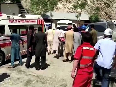People wheel a gurney towards an ambulance outside a hospital in Dasu, after a bus with Chinese nationals on board plunged into a ravine in Upper Kohistan following a blast, Pakistan July 14, 2021 in this still image taken from video. 