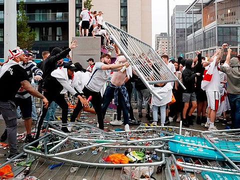 England fans throw barriers outside Wembley Stadium during the Euro 2020 final against Italy.