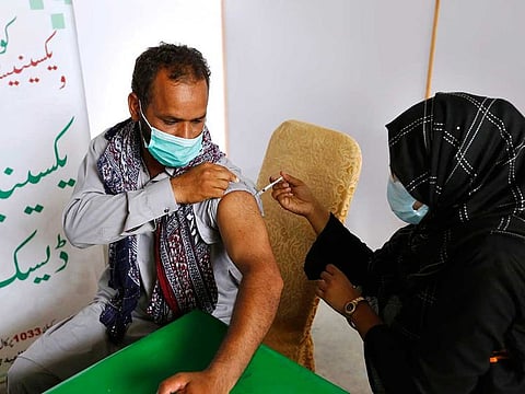 A man receives the Moderna COVID-19 vaccine from a health worker at a vaccination center, in Lahore, Pakistan, Tuesday, July 6, 2021. 