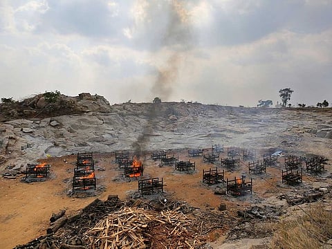 In this May 5, 2021, file photo, funeral pyres of 25 COVID-19 victims burn at an open crematorium set up at a granite quarry on the outskirts of Bengaluru, India. India's excess deaths during the pandemic could be a staggering 10 times the official COVID-19 toll, likely making it modern India's worst human tragedy, according to the most comprehensive research yet on the ravages of the virus in the south Asian country. 