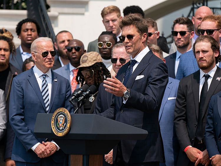 President Joe Biden listens to Tampa Bay Buccaneers quarterback Tom Brady speak during a ceremony on the South Lawn of the White House