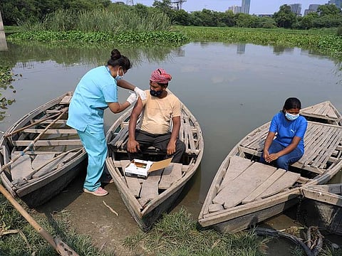 A health worker administers a vaccine for COVID-19 to a boatman on an island in the River Yamuna in New Delhi, India, Friday, July 16, 2021. 