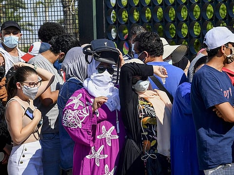 Tunisians wait to receive a dose of the Chinese Sinopharm vaccine outside the Palais des Congres in the capital Tunis on July 20, 2021.