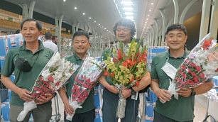 South Korean climber Kim Hong-Bin (2nd right) along with team members hold bouquets at the airport in Islamabad on June 16, 2021.  