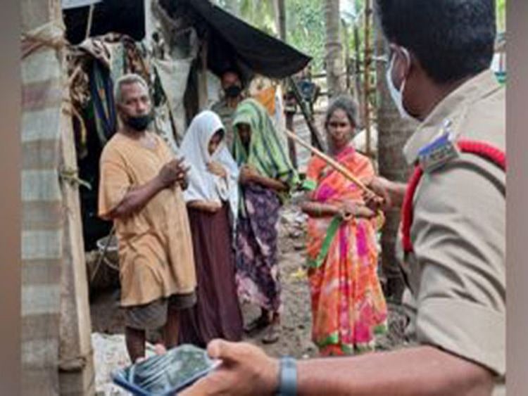  A policeman speaks to the family after they were 'freed' from the tent house.