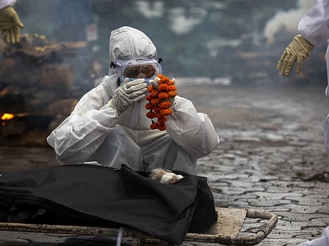 A relative performs last rites before the cremation of a COVID-19 victim in Gauhati, India, in a file photo. The Indian government said on Thursday it was an “audacious assumption that the likelihood of any given infected person dying is the same across countries”.